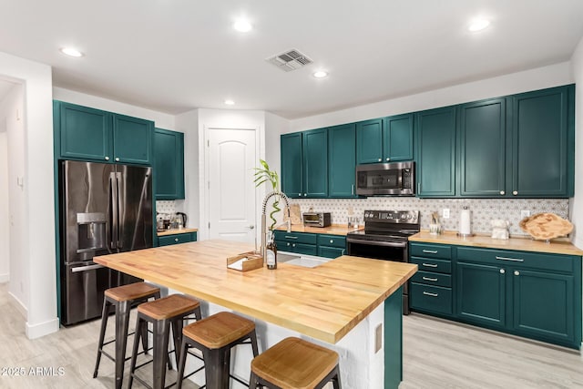 1736 E Joelle Dr, Casa Grande, AZ 85122 - kitchen with stainless steel appliances, a sink, backsplash, butcher block counters, and light wood-style flooring