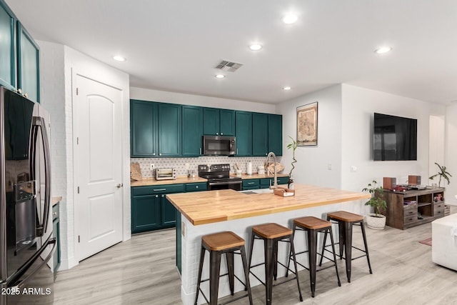1736 E Joelle Dr, Casa Grande, AZ 85122 - kitchen featuring refrigerator with ice dispenser, electric range, stainless steel microwave, light wood finished floors, and a breakfast bar area