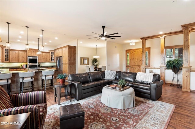 living room with ceiling fan, decorative columns, and hardwood / wood-style flooring