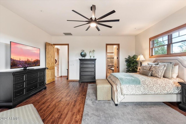 bedroom with connected bathroom, ceiling fan, and dark hardwood / wood-style floors