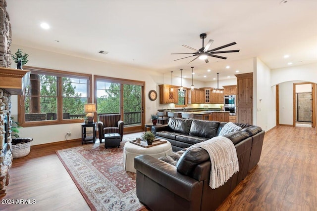 living room with ceiling fan, wood-type flooring, and sink