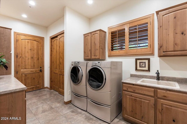 laundry room with washer and clothes dryer, sink, light tile patterned floors, and cabinets