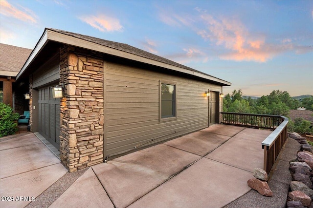 property exterior at dusk featuring a garage