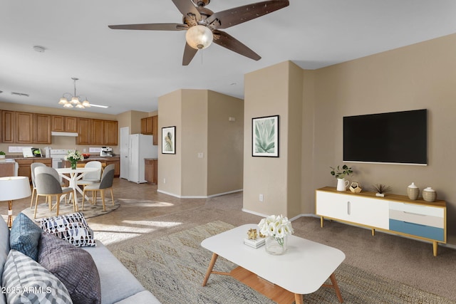 living room with ceiling fan with notable chandelier