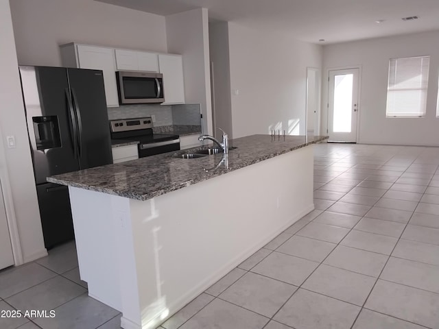 kitchen with white cabinetry, sink, stainless steel appliances, a center island with sink, and light tile patterned floors