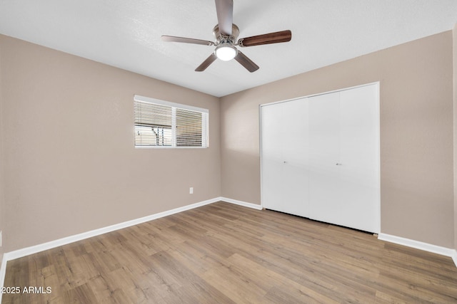 9639 W Cinnabar Ave Unit A, Peoria, AZ 85345 - unfurnished bedroom featuring wood finished floors, baseboards, a closet, and a ceiling fan