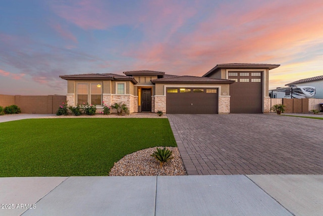 prairie-style home featuring a garage and a yard