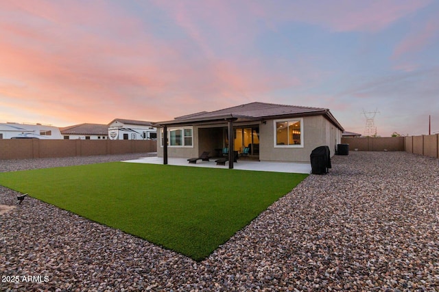 back house at dusk with a patio