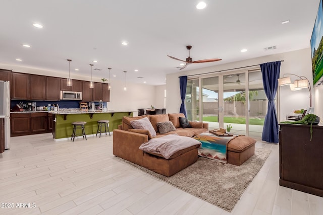 living room featuring ceiling fan and light hardwood / wood-style flooring