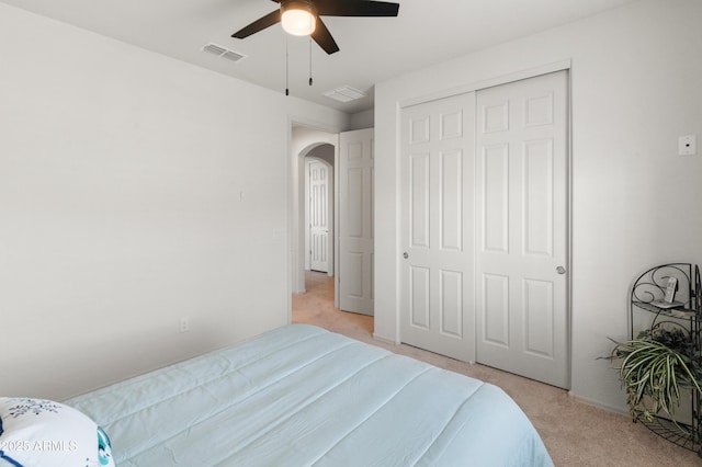 bedroom featuring light carpet, a closet, and ceiling fan