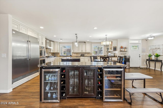 bar featuring wall chimney range hood, wine cooler, hanging light fixtures, and stainless steel appliances