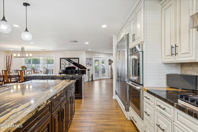 kitchen with an inviting chandelier, decorative light fixtures, french doors, white cabinets, and hardwood / wood-style flooring