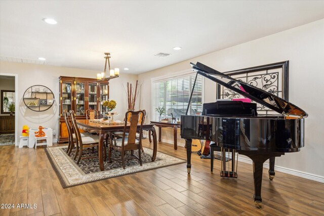 dining area with an inviting chandelier and hardwood / wood-style flooring