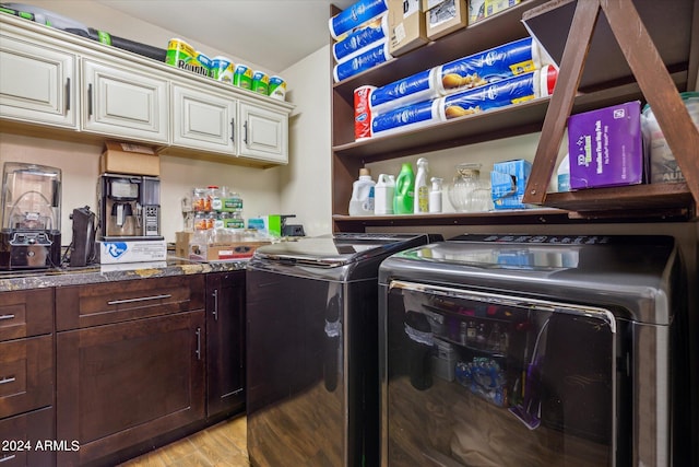 laundry room with cabinets, light wood-type flooring, and washing machine and dryer