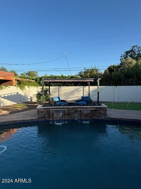 view of pool featuring pool water feature and a patio area