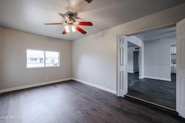 unfurnished room with ceiling fan and dark wood-type flooring