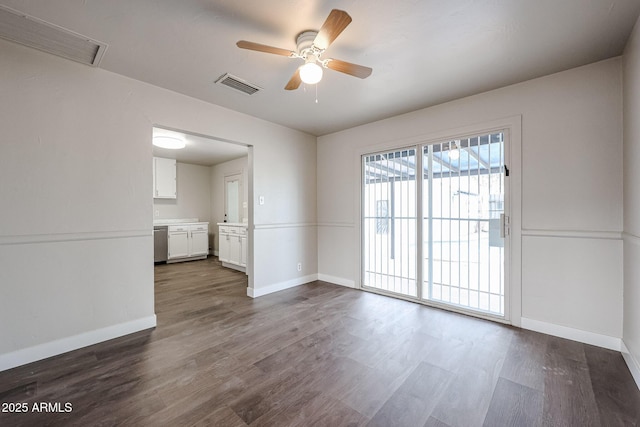 spare room featuring dark hardwood / wood-style flooring and ceiling fan