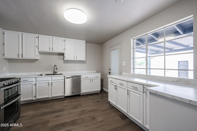 kitchen featuring dark wood-type flooring, sink, white cabinets, and stainless steel appliances