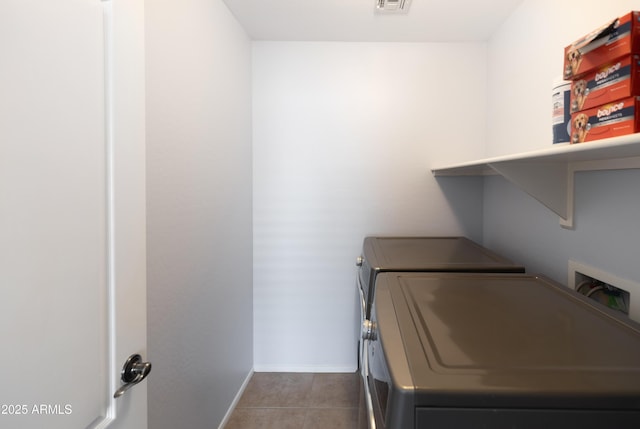 clothes washing area featuring tile patterned floors and washing machine and dryer