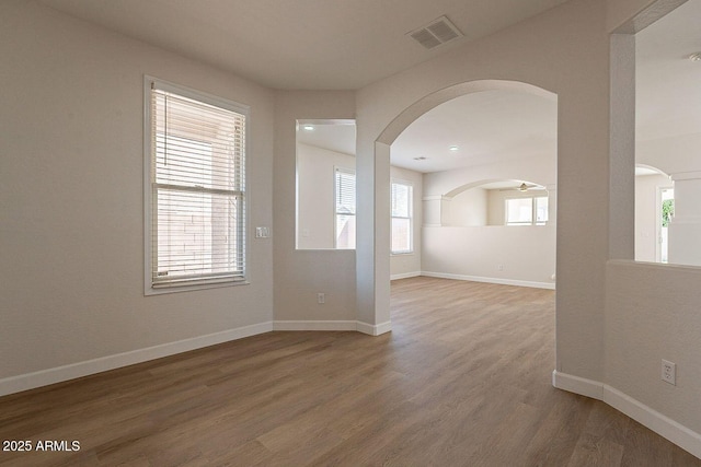 18123 W Lundberg St, Surprise, AZ 85388 - spare room featuring plenty of natural light, arched walkways, wood finished floors, and baseboards