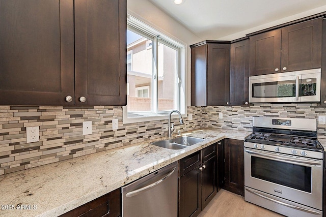 18123 W Lundberg St, Surprise, AZ 85388 - kitchen with stainless steel appliances, a sink, dark brown cabinets, and decorative backsplash