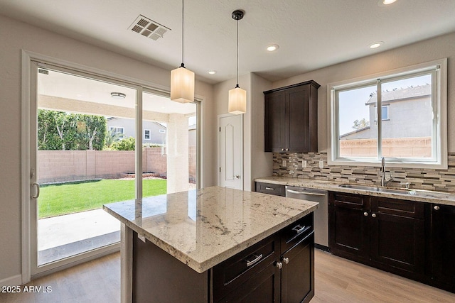 18123 W Lundberg St, Surprise, AZ 85388 - kitchen with stainless steel dishwasher, light wood finished floors, plenty of natural light, decorative backsplash, and recessed lighting