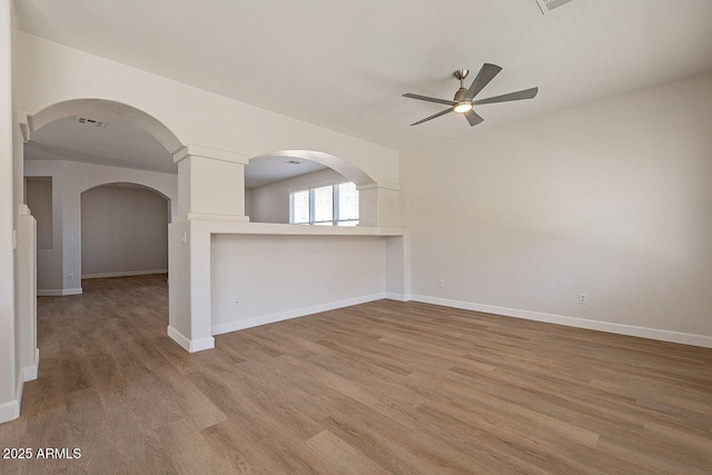 18123 W Lundberg St, Surprise, AZ 85388 - unfurnished room featuring ceiling fan, light wood finished floors, baseboards, and arched walkways
