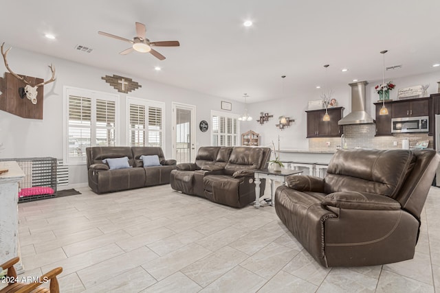 living room featuring ceiling fan with notable chandelier