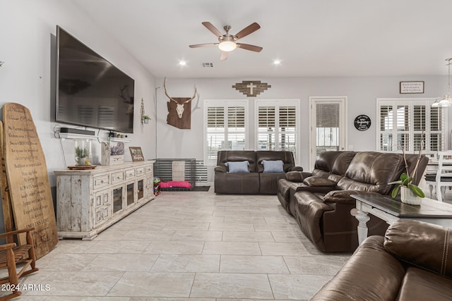 living room featuring ceiling fan with notable chandelier