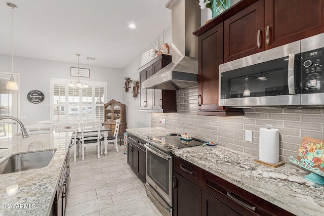 kitchen featuring appliances with stainless steel finishes, plenty of natural light, sink, and wall chimney range hood