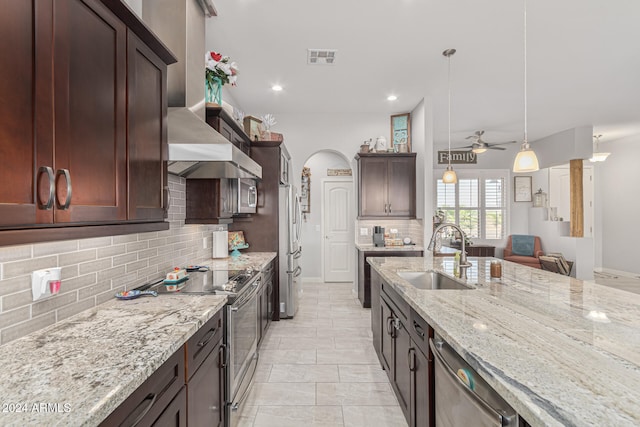 kitchen with ceiling fan, sink, decorative light fixtures, backsplash, and stainless steel appliances