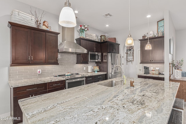 kitchen featuring pendant lighting, appliances with stainless steel finishes, backsplash, and sink