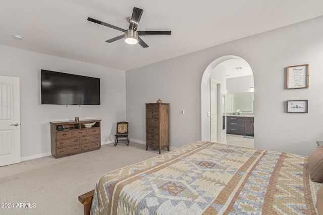 carpeted bedroom with ceiling fan and ensuite bath