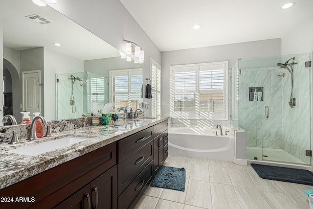 bathroom with shower with separate bathtub, tile patterned floors, vaulted ceiling, and vanity