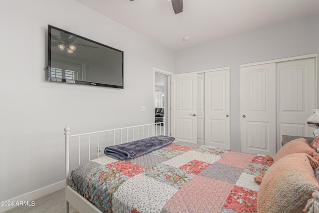 carpeted bedroom with multiple closets and ceiling fan