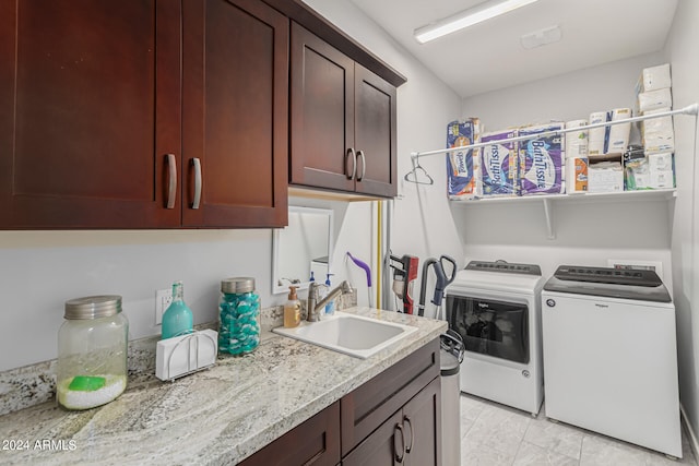 laundry room featuring cabinets, washing machine and dryer, and sink