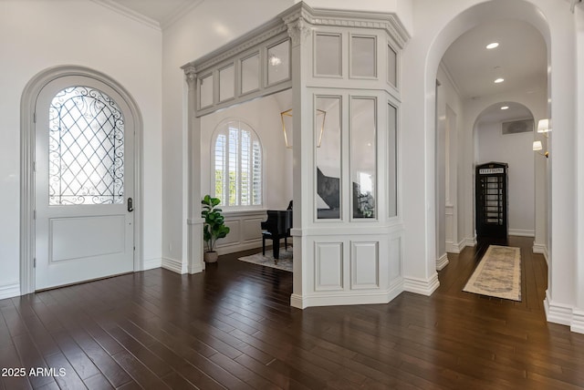 entryway featuring dark wood-type flooring and crown molding