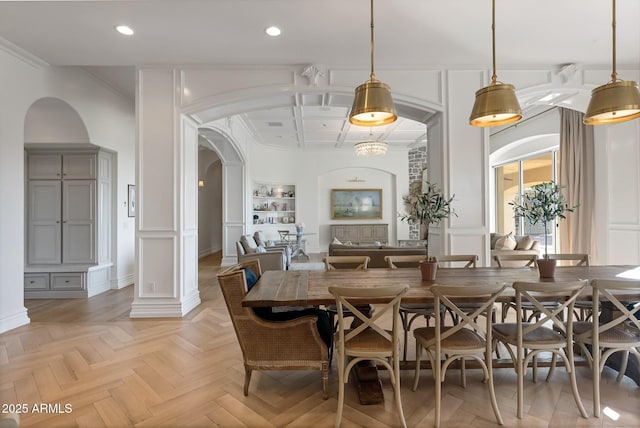 dining area with ornate columns, light parquet flooring, coffered ceiling, and crown molding