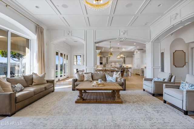 living room featuring coffered ceiling and a chandelier