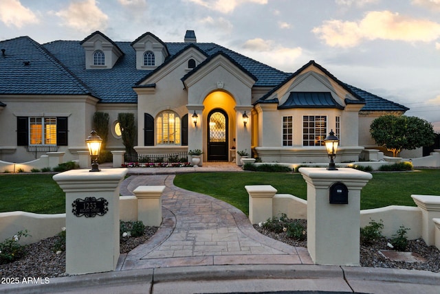 french country inspired facade featuring a front lawn