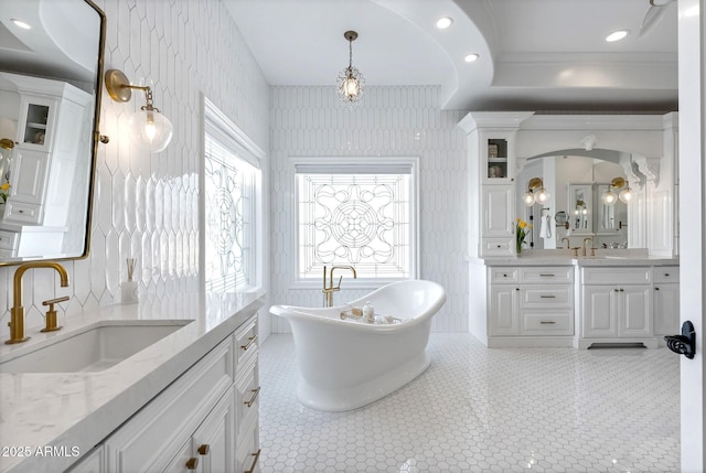 bathroom featuring tile patterned flooring, vanity, and a tub