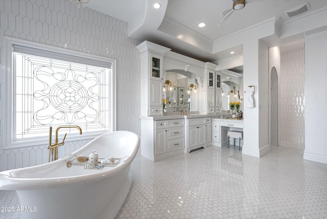 bathroom with vanity, a bath, crown molding, and tile patterned floors