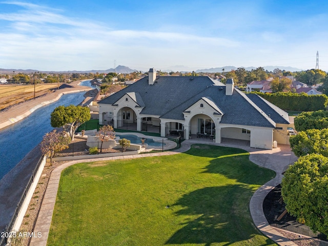 exterior space featuring a fenced in pool, a yard, and a mountain view