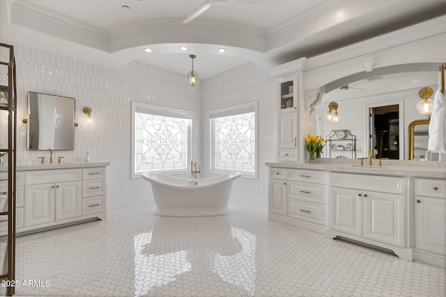 bathroom featuring crown molding, vanity, a bathtub, and tile patterned floors