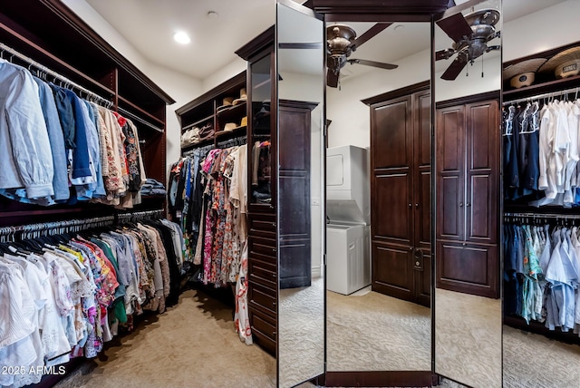 spacious closet featuring ceiling fan, light colored carpet, and stacked washer and clothes dryer