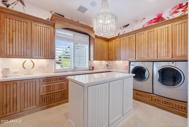 washroom with sink, cabinets, separate washer and dryer, light tile patterned floors, and a notable chandelier