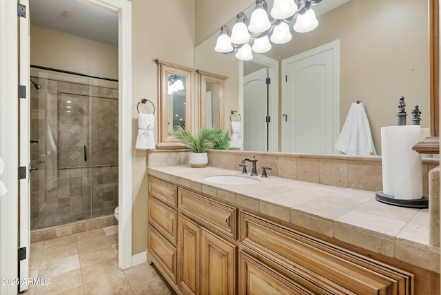 bathroom featuring vanity, toilet, a chandelier, and a shower with door