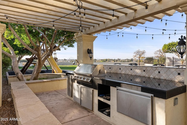 view of patio featuring exterior kitchen, area for grilling, and a playground