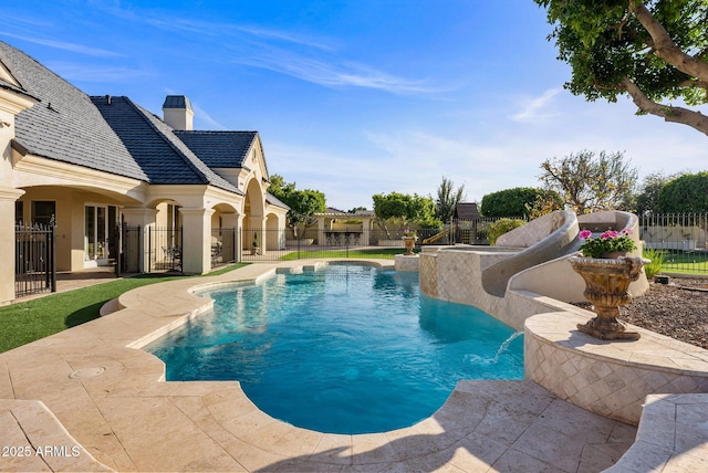 view of swimming pool featuring pool water feature, a water slide, and a patio