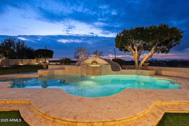 pool at dusk with a patio area